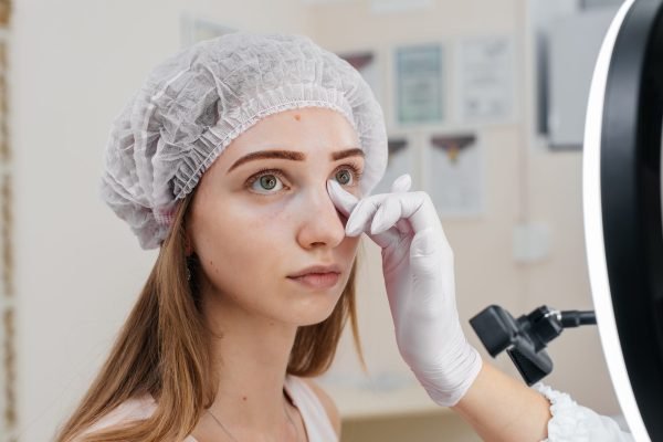 Cosmetic procedure for filling the nasolacrimal furrow and mesotherapy around the eyes for a young beautiful girl. Modern cosmetology.